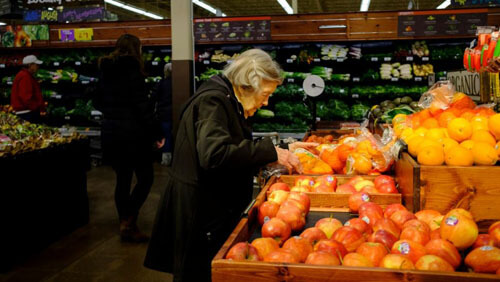 Студент помогает пожилым покупателям, опасающимся ходить по магазинам