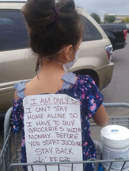 Девочка, совершающая покупки вместе с мамой, носит на спине специальный плакат